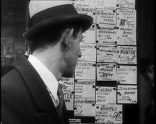 A Male Civilian Looking at a Board With Job Advertisements, 1932. Creator: British Pathe Ltd