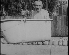 A Male Civilian Sitting in a Bath Before the Bath is Lifted Off the Ground By a Hot Air..., 1920s. Creator: British Pathe Ltd