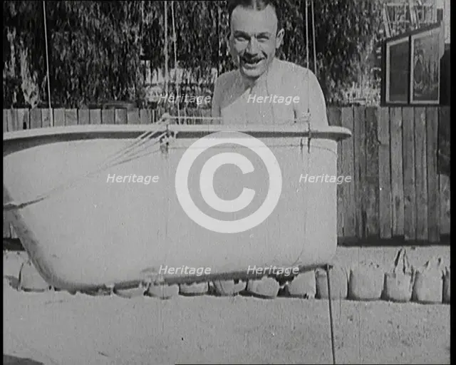 A Male Civilian Sitting in a Bath Before the Bath is Lifted Off the Ground By a Hot Air..., 1920s. Creator: British Pathe Ltd.