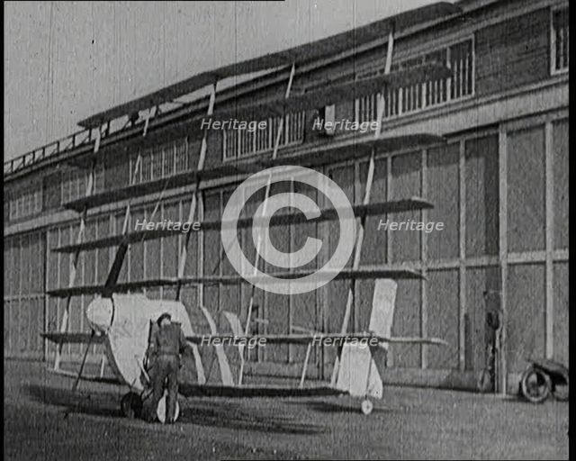 A Male Pilot Getting Into an Early Seven Winged Plane, 1922. Creator: British Pathe Ltd.