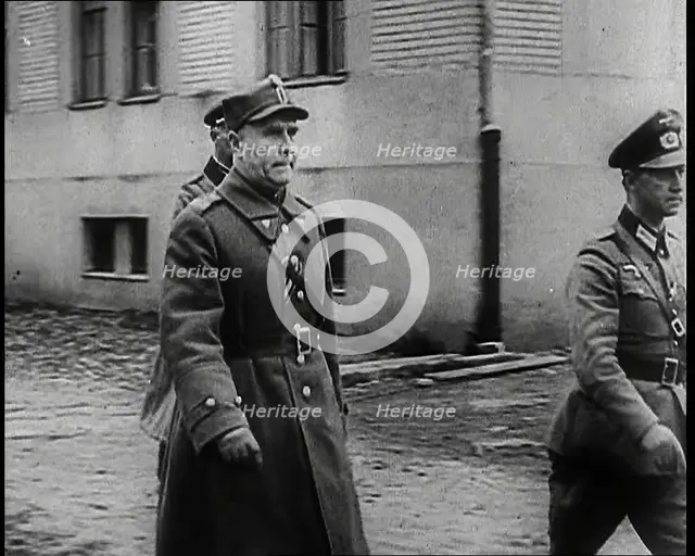 A Male Polish Army Commander Walking Past the Corner of a Large Building With Two Male... 1939. Creator: British Pathe Ltd.