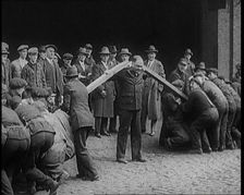 A Male Stuntman Bending Girders Over His Shoulders, 1926. Creator: British Pathe Ltd