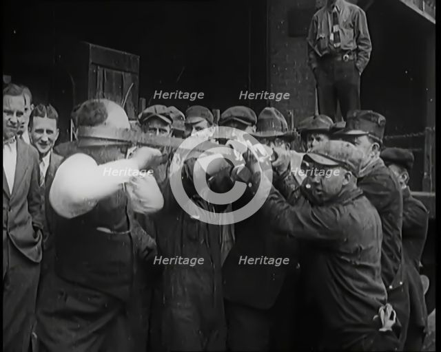 A Male Stuntman Bending Iron Bars Around His Head, 1926. Creator: British Pathe Ltd.