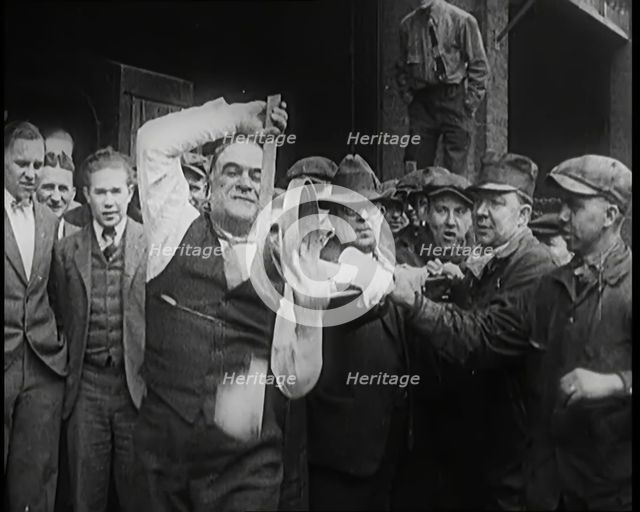 A Male Stuntman Bending Iron Bars Around His Head, 1926. Creator: British Pathe Ltd.