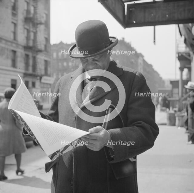 A Marcus Garveyite reading the OWI publication Negroes and the War, New York, 1943. Creator: Gordon Parks.