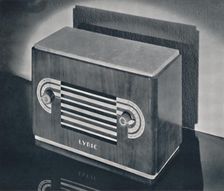 A midget radio cabinet in wood veneer, with aluminum grill and dials 1935. Artist: Dana Merrill