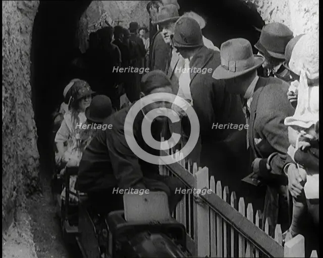 A Model Train Passes Through a Tunnel As a Crowd of People Watch from Behind a Fence, 1924. Creator: British Pathe Ltd.