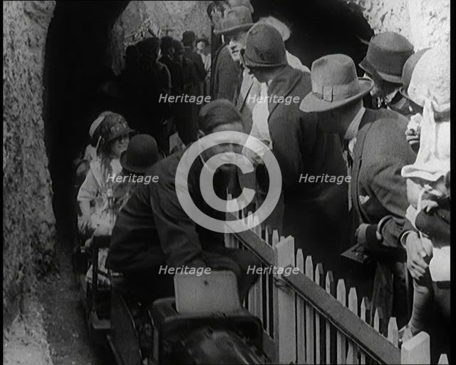 A Model Train Passes Through a Tunnel As a Crowd of People Watch from Behind a Fence, 1924. Creator: British Pathe Ltd.