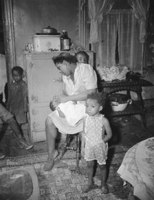 A mother getting the children ready for a neighborhood birthday party,Washington, D.C., 1942. Creator: Gordon Parks