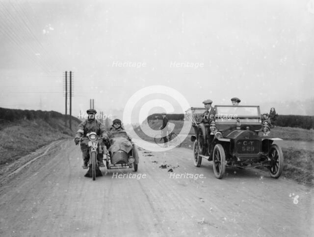 A motorcycle and sidecar passing a car and cyclist on the road. Artist: Unknown
