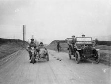 A motorcycle and sidecar passing a car and cyclist on the road