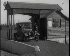 A Motorcar Driving Into the Forecourt of the First Petrol Station, 1920. Creator: British Pathe Ltd