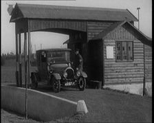 A Motorcar Driving Into the Forecourt of the First Petrol Station, 1920. Creator: British Pathe Ltd