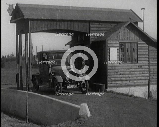 A Motorcar Driving Into the Forecourt of the First Petrol Station, 1920. Creator: British Pathe Ltd.