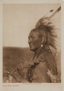 A Native American man from the Arapaho tribe wearing a feathered headdress, 1927. Creator: Edward Sheriff Curtis
