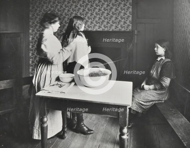 A nurse examines girls' hair, Central Street Cleansing Station, London, 1914. Artist: Unknown.