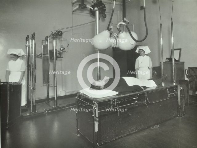 A patient undergoes a medical procedure, c1950s. Creator: Unknown.