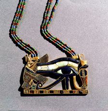 A pendant from the tomb of Tutankhamun in the form of a Wedjat eye symbol of protection, flanked by the vulture goddess, Nekhbet and the snake goddess Wadjet, protectors of Upper & Lower Egypt