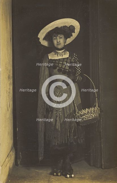 A person wearing a dress, large hat and roller skates, poses holding a basket, (1910-1919?). Creator: Unknown.