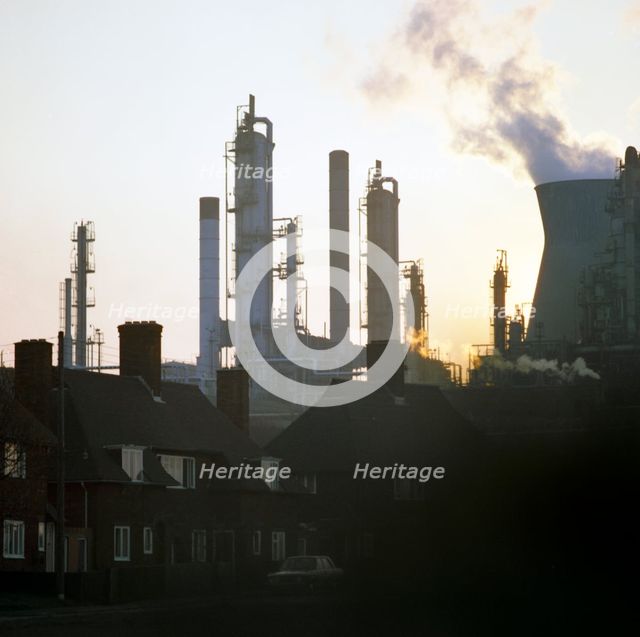 A petrochemical plant towering over residential housing, Baglan Bay, Wales, 1975. Artist: Michael Walters
