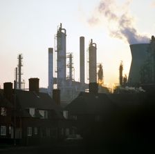 A petrochemical plant towering over residential housing, Baglan Bay, Wales, 1975. Artist: Michael Walters
