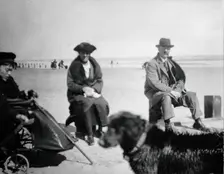 A physically disabled boy sitting in a wheelchair on a beach, c1910/1925. Creator: Unknown