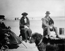 A physically disabled boy sitting in a wheelchair on a beach, c1910/1925. Creator: Unknown