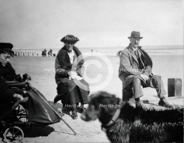 A physically disabled boy sitting in a wheelchair on a beach,  c1910/1925. Creator: Unknown.