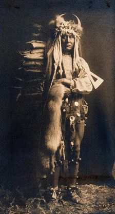 A Piegan man, Iron Breast, in ceremonial dress, 1900. Creator: Edward Sheriff Curtis