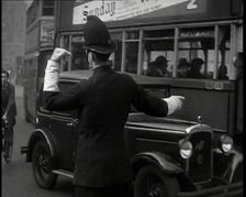 A Police Officer Guiding Traffic on the Streets of London, 1936. Creator: British Pathe Ltd