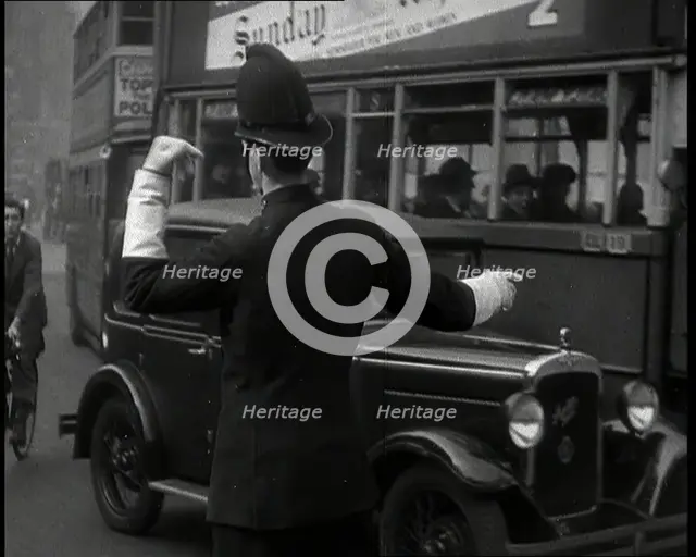 A Police Officer Guiding Traffic on the Streets of London, 1936. Creator: British Pathe Ltd.