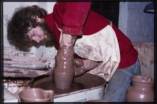 A potter working at a wheel in the Gladstone Pottery Museum, Longton, Stoke-on-Trent, 1975. Creator: Dorothy Chapman