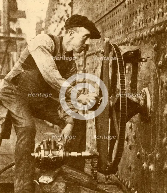 'A Pneumatic Riveter Cutting Portholes in the Side of a Liner', c1930. Creator: John Brown & Company.