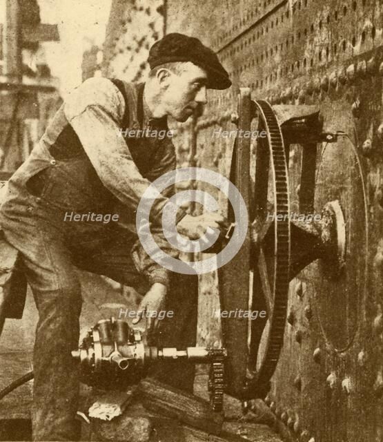 'A Pneumatic Riveter Cutting Portholes in the Side of a Liner', c1930. Creator: John Brown & Company.