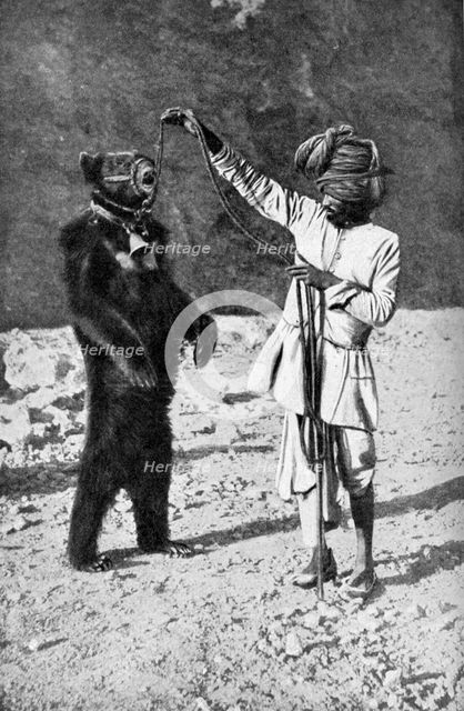 A Punjabi native with a dancing bear, India, 1922.Artist: Robert Chisham