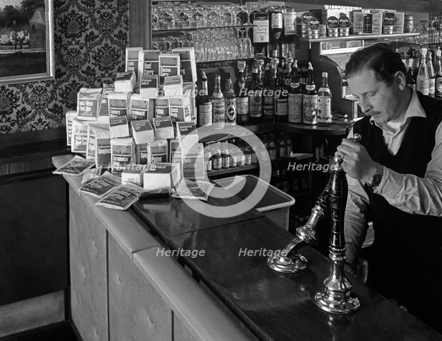 A pub landlord with a display of the Batchelors 5 day catering pack on his bar, 1968. Artist: Michael Walters