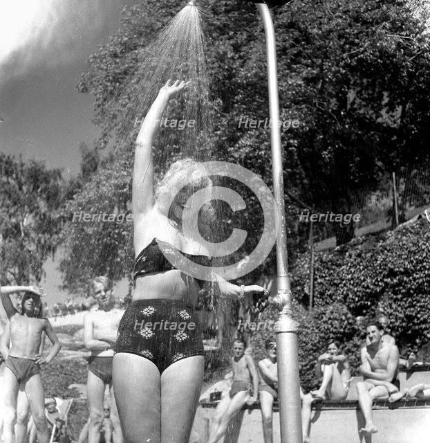 A refreshing shower during the heatwave in Stockholm, Sweden, 24th July 1943. Creator: Karl Sandels.