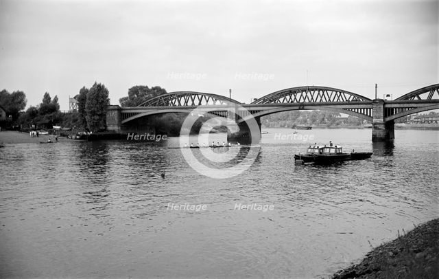 A rowing eight passes under Barnes Bridge, Chiswick, London, c1945-c1965.  Artist: SW Rawlings