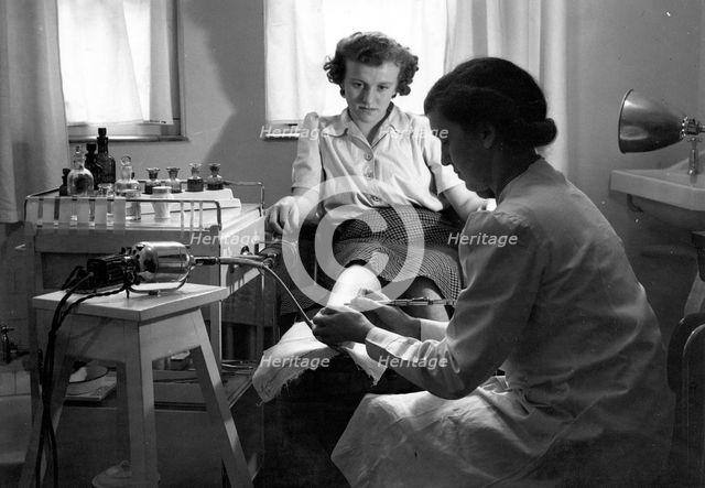A Rowntree’s chiropodist works on a woman’s foot, York, Yorkshire, 1946. Artist: Unknown