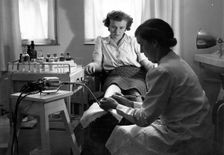 A Rowntree’s chiropodist works on a woman’s foot, York, Yorkshire, 1946