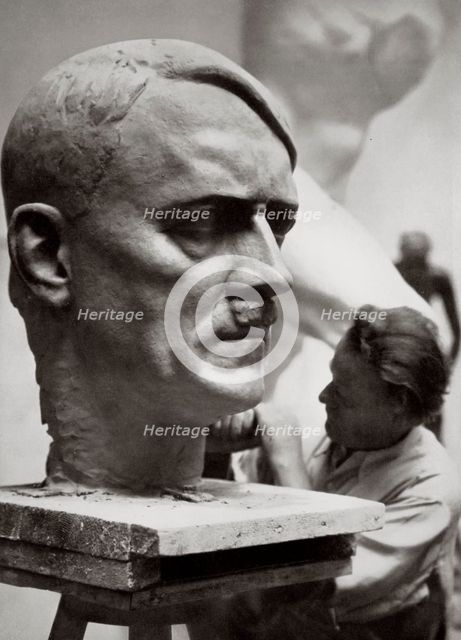 A sculptor working on a large portrait bust of Adolf Hitler, Germany, 1936. Artist: Unknown