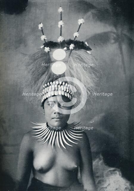 A Samoan woman wearing a collar of cachalots' teeth and a ceremonial headdress, 1902. Artist: Josiah Martin.