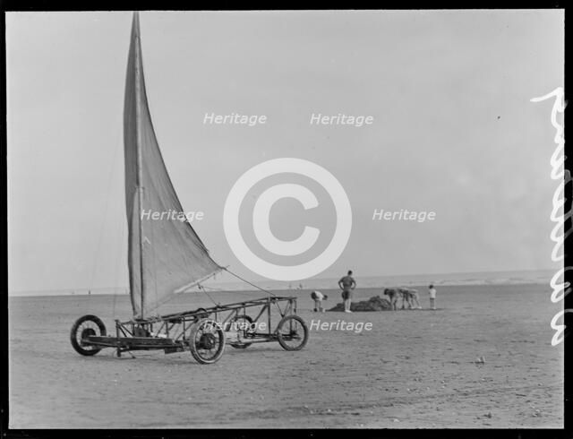 A sand yacht on West Wittering Beach with people digging in the sand, Chichester, West Sussex, 1930s Creator: George R Long.