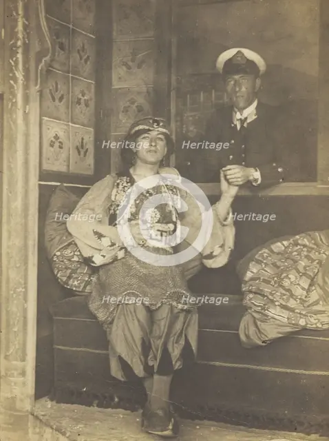 A sailor holds hands with a man in elaborate drag, [between 1910 and 1999?]. Creator: Unknown.