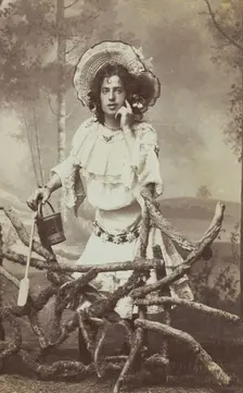 A sailor in drag posed behind a wooden fence, 1906. Creator: Unknown
