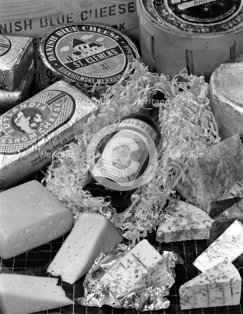 A selection of Danish cheeses and a bottle of Aalborg aquavit, 1963. Creator: Michael Walters.