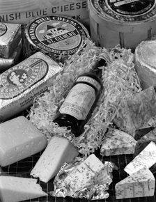 A selection of Danish cheeses and a bottle of Aalborg aquavit, 1963. Creator: Michael Walters