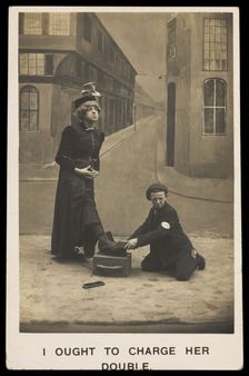 A shoeshine boy cleans the boots of a man in drag, c1905. Creator: Unknown