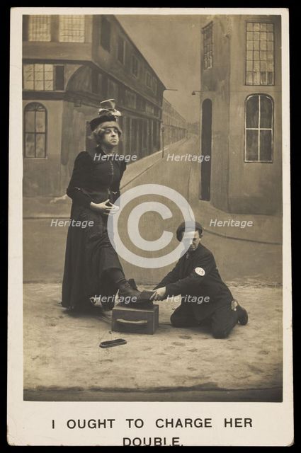 A shoeshine boy cleans the boots of a man in drag, c1905. Creator: Unknown.