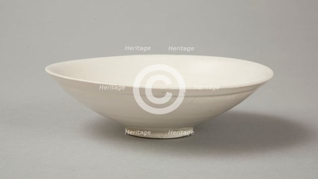 A shallow cream glazed bowl with rolled rim andraised footrim, Tang dynasty, c.800-900. Creator: Unknown.